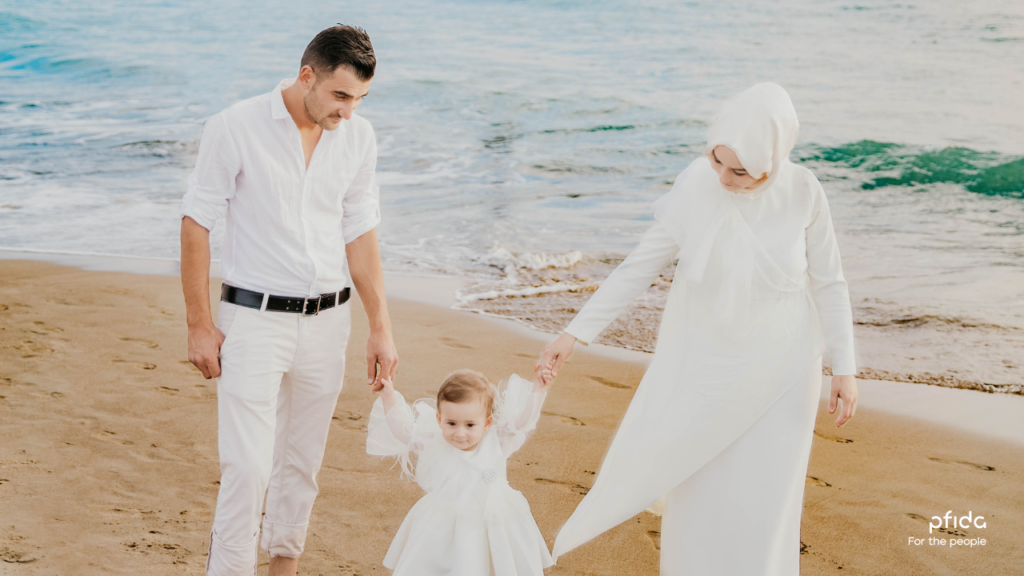 A young Muslim couple and their child dressed in white on the beach | A Deep Dive into Pfida's Shariah-Compliant Home Finance with Sheikh Asim Khan