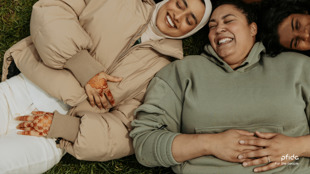 Three female friends laughing and having fun whilst laying on the ground | A Deep Dive into Pfida's Shariah-Compliant Home Finance with Sheikh Asim Khan